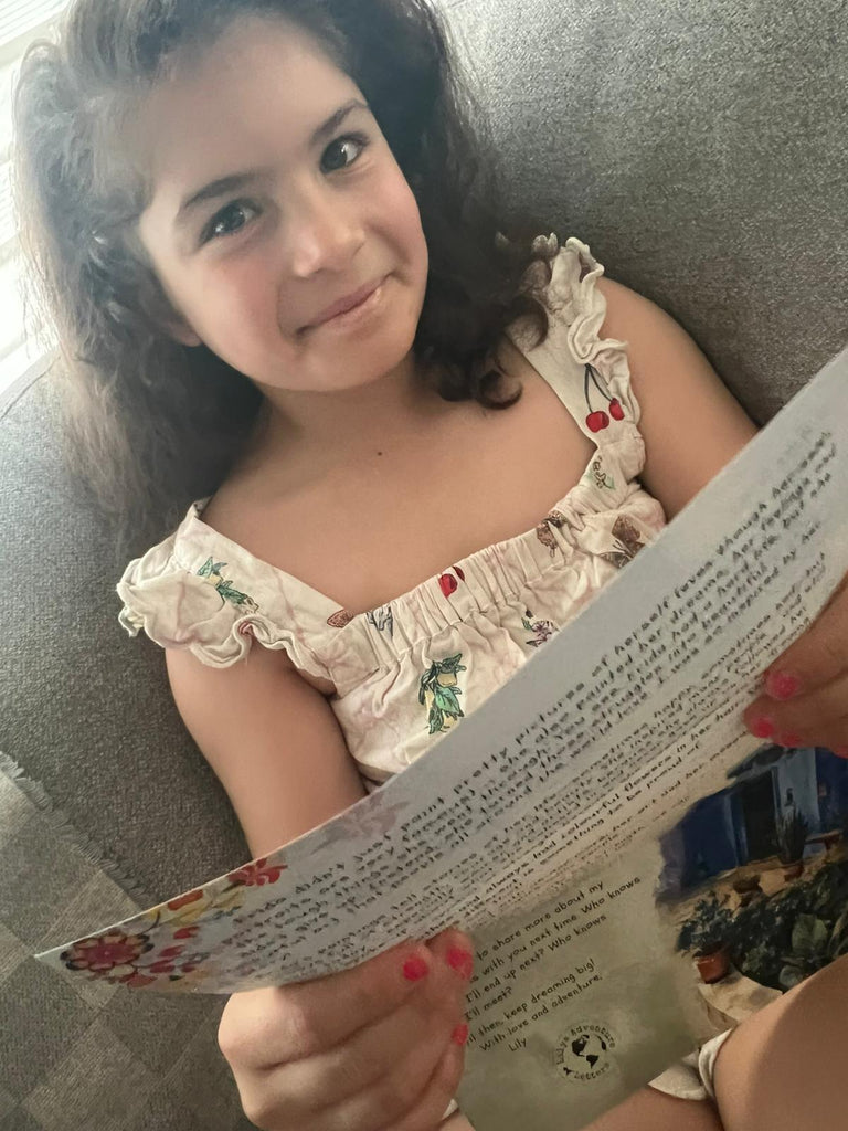 child smiling whilst reading  a lilys adventure letter